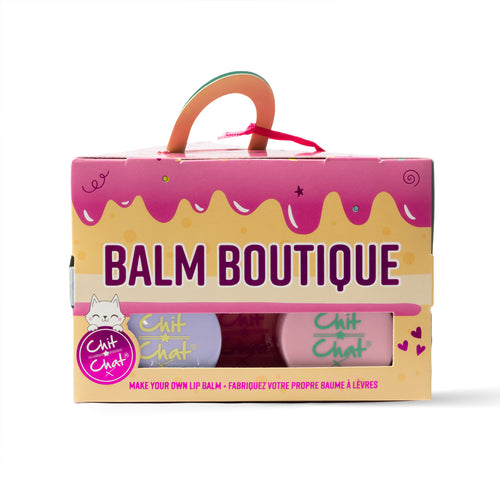 A boxed lip balm making set labeled 'BALM BOUTIQUE' with pink and cream packaging, a handle cut out, and two visible balm tubs inside. The package also shows the Chit Chat brand logo.